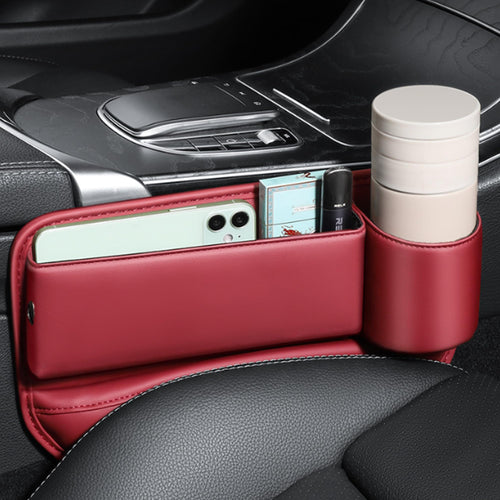 Red seat gap filler installed beside the center console holding a phone and cups