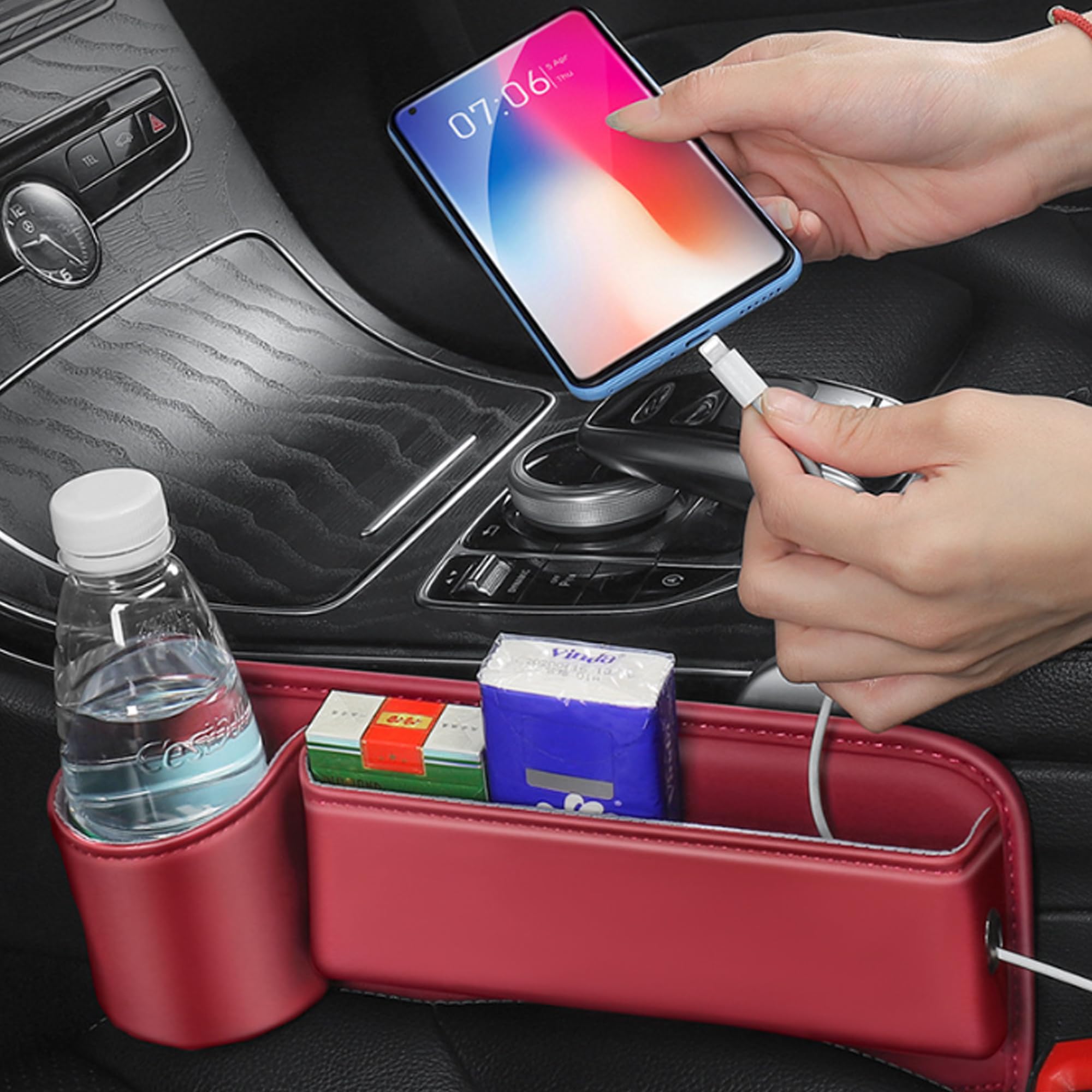 Seat gap filler holding a phone, tissues and a drink bottle, with a charging cable run through the side port